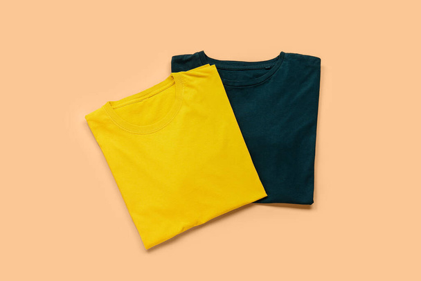 Stylish t-shirts on color background - Fotoğraf, Görsel