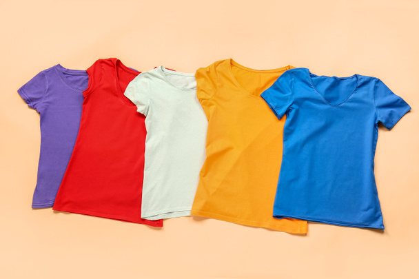Stylish t-shirts on color background - 写真・画像