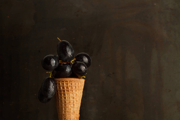Tumbas negras en un cono de oblea y sobre un fondo oscuro
 - Foto, imagen