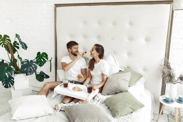 Couple sitting on a bed in a room - Foto, imagen