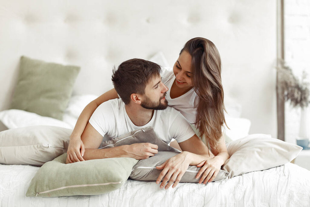 Couple sitting on a bed in a room - Photo, Image