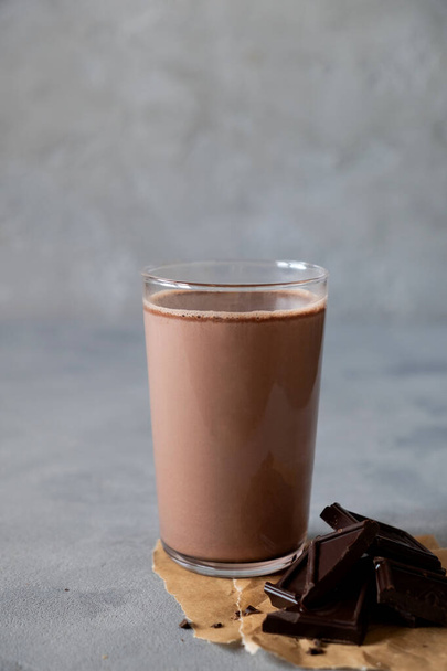 Glass of tasty chocolate milk on gray table. Dairy cacao drink - Фото, изображение