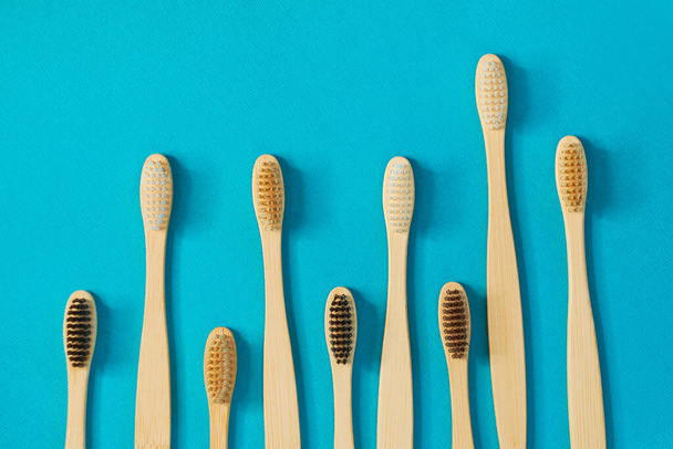 Wooden toothbrushes on a blue background. zero waste concept. dental care without platysik. - Foto, Bild