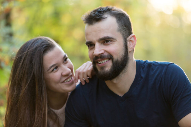 Retrato de jovem casal bonito no Parque. No fundo de folhas de árvores. Tiro enquadrado horizontalmente
. - Foto, Imagem