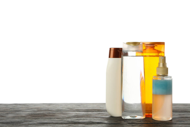 Botellas de cosméticos en blanco sobre mesa de madera aislada sobre fondo blanco
 - Foto, imagen