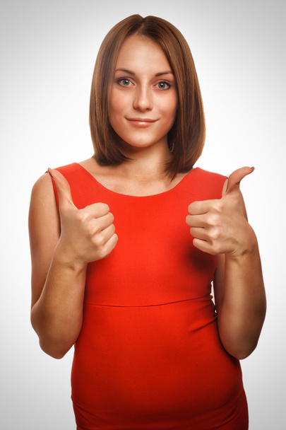 Fille femme jeune signe positif pouces oui en robe rouge fond d'émotion
 - Photo, image