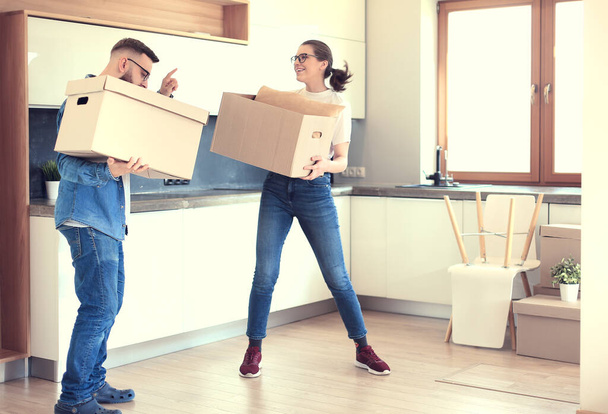 Couple holding boxes for moving the hands and looking inside box - 写真・画像