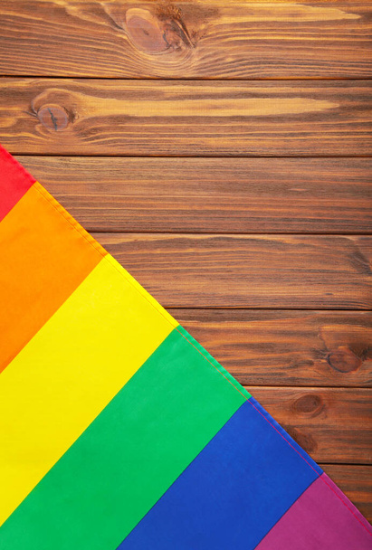 Rainbow LGBT flag on brown wooden background, top view - Foto, Bild