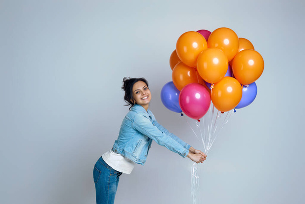 girl in denim posing with bright colorful air balloons - Fotografie, Obrázek