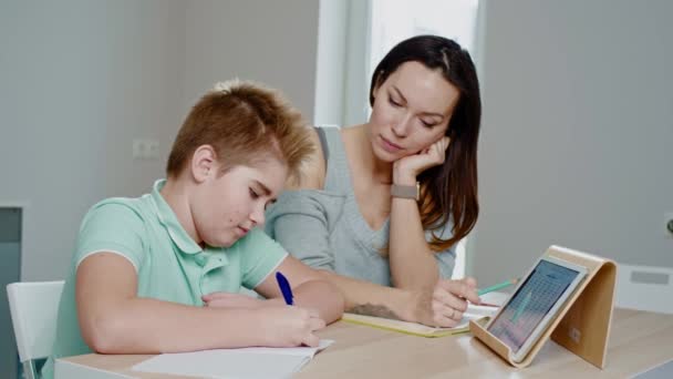 Mother with her son studying online at home - Video
