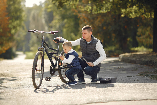 Father with son repare the bike in a park - Φωτογραφία, εικόνα