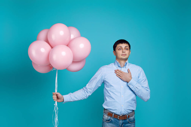 man in shirt holding pink air balloons - Zdjęcie, obraz