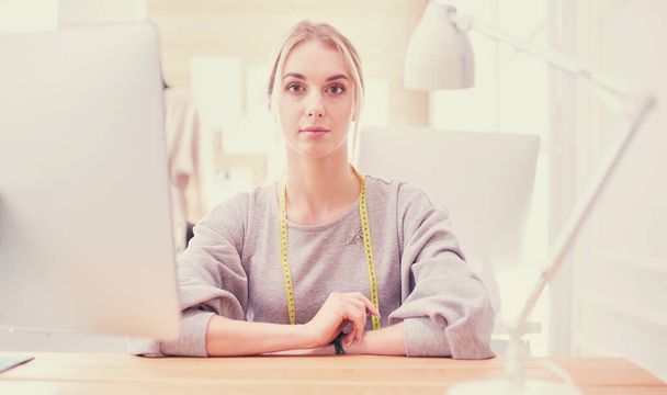 Fashion designer woman working in studio, sitting at thhe desk - Fotoğraf, Görsel