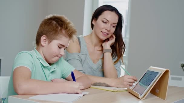 Mother with her son studying online at home - 映像、動画