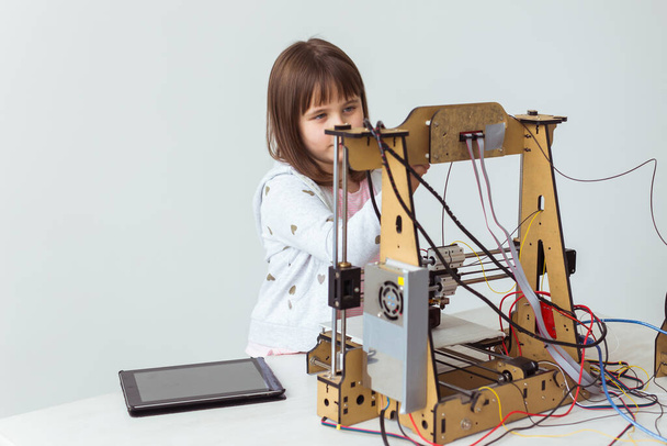 Little child architect using 3D Printer. Schoolgirl, technologies and study concept. - Photo, Image