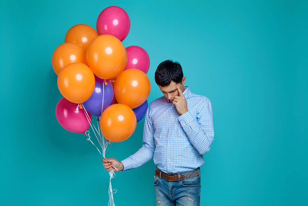 Καυκάσιος άνδρας σε πουκάμισο με φωτεινά πολύχρωμα μπαλόνια - Φωτογραφία, εικόνα