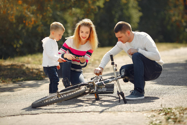 Family with son repare the bike in a park - 写真・画像