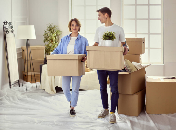 Couple holding boxes for moving the hands and looking inside box - Foto, Imagem