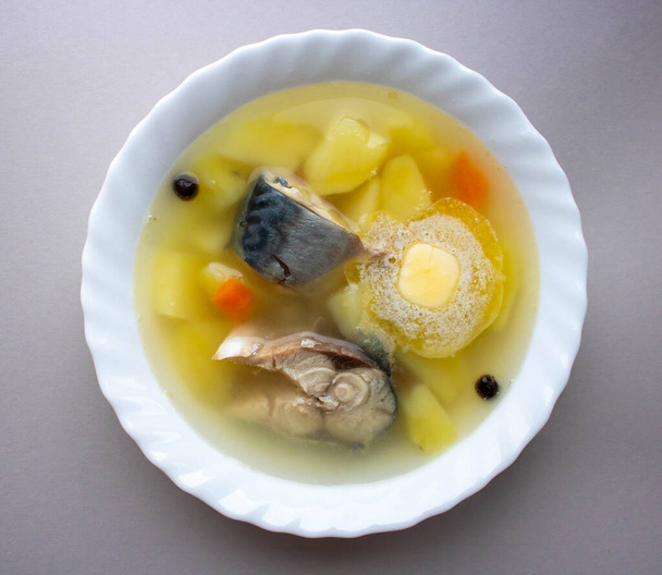 Вкусный суп из морской рыбы в белой тарелке на сером столе
. - Фото, изображение