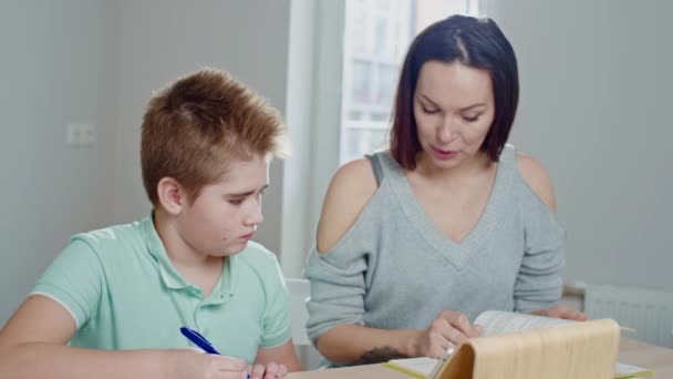Mother with her son studying online at home - Video