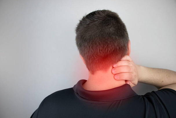 Мужчина страдает от боли в шее, массирует шейный отдел позвоночника рукой. Остеохондроз, грыжа или повреждение нерва из-за сидячей работы или физического стресса
 - Фото, изображение