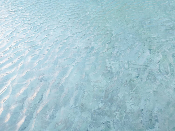 Hullámzó minta élénk türkiz kék víz a medence felett kő csempe lágy fény tükröződik a napsütés - Fotó, kép