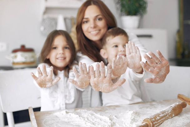 Rodzina siedzi w kuchni i gotować ciasto na ciasto - Zdjęcie, obraz
