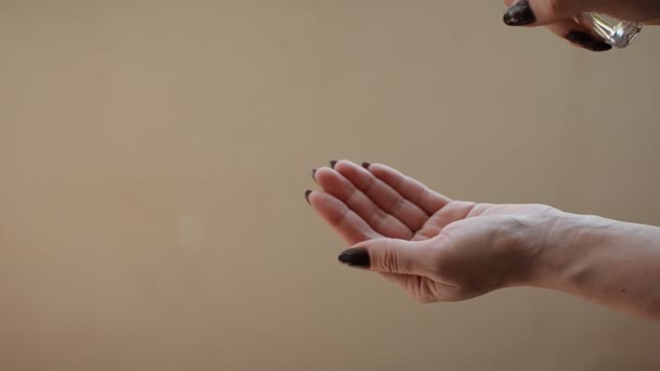 Woman sprinkles antibacterial sanitizer on her hands - Materiał filmowy, wideo