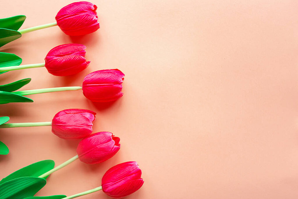 tulipanes rojos sobre fondo rosa pastel. Copia espacio para el texto. Tarjeta de felicitación del Día de la Madre o del Día de la Mujer
 - Foto, Imagen
