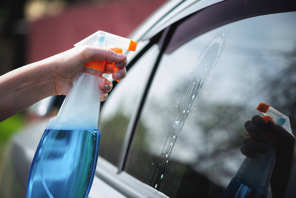 Cleaner is cleaning a car window glass with a rag and detergent close up. - Valokuva, kuva