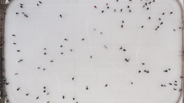 Вид сверху на зимний каток и людей, катающихся на коньках в замедленном режиме. Зимний каток на свежем воздухе. Полезный и интересный вид спорта для здоровья. Новый год и Рождество в Харькове, Украина 2020
. - Кадры, видео