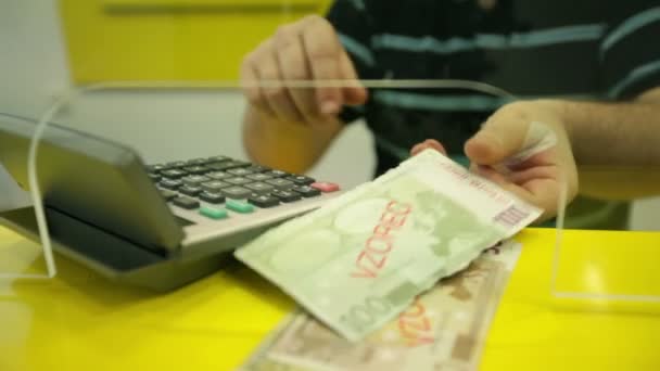 Banquier derrière le verre comptant l'argent de l'euro
 - Séquence, vidéo