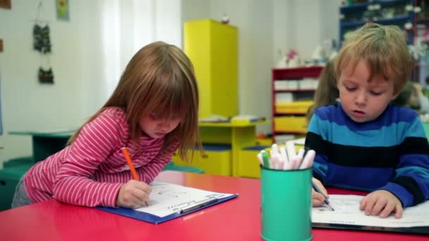 kinderen in de kleuterschool tekenen op papier - Video