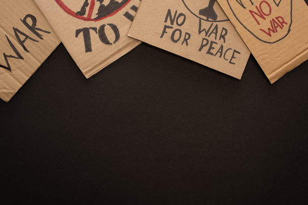 vista superior de carteles de cartón sin letras de guerra sobre fondo negro
 - Foto, imagen