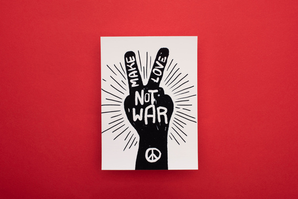 top view of drawing with make love not war lettering and peace sign on red background - Фото, изображение
