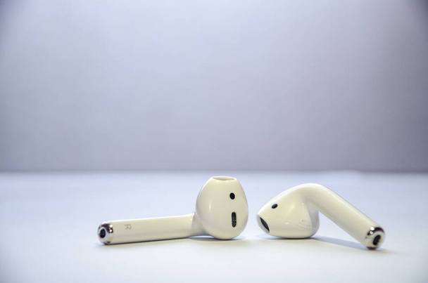 Λευκά ασύρματα ακουστικά σε λευκό φόντο. - Φωτογραφία, εικόνα