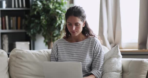 Excited young lady winning online bid on laptop at home - Filmagem, Vídeo