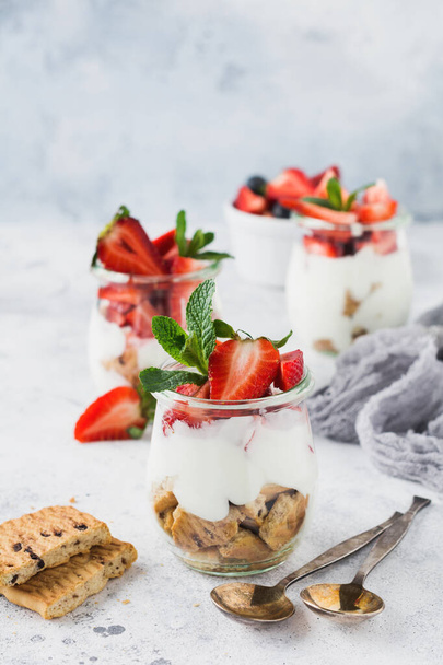 No baked dessert treifl or cheesecake with strawberries in sliced jars on an old concrete background. Selective focus. - Foto, imagen