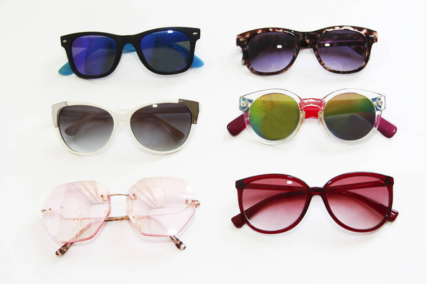 sluneční brýle s vícebarevnými čočkami a rámečky na bílém pozadí - Fotografie, Obrázek