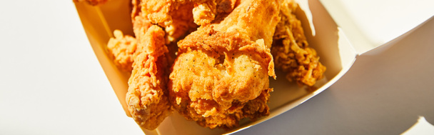 close up view of tasty deep fried chicken with chili pepper on white table in sunlight, panoramic crop - Φωτογραφία, εικόνα