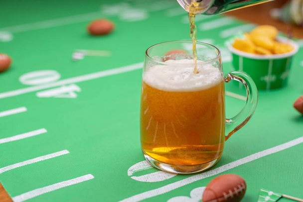 game day beer and snacks on table decorated for the superbowl - Photo, Image