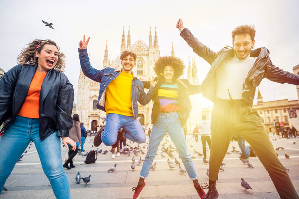 Grupo de amigos multiétnicos saltando frente a la catedral de Milán - celebración, libertad, concepto de victoria - Foto, imagen