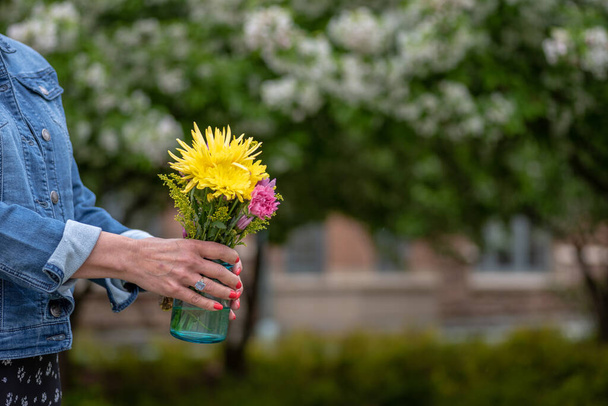 femme portant un bouquet de fleurs fraîches cueillies à la main
 - Photo, image