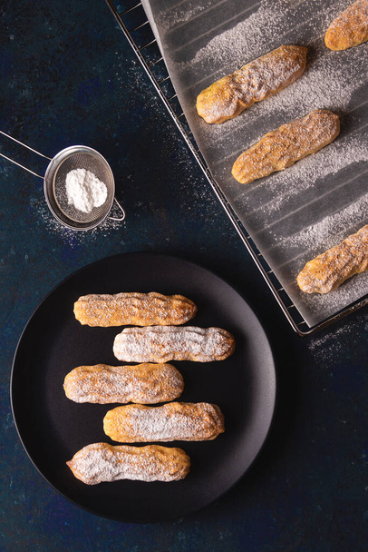 Sušenky Savoyardi posypané práškovým cukrem na modré - Fotografie, Obrázek