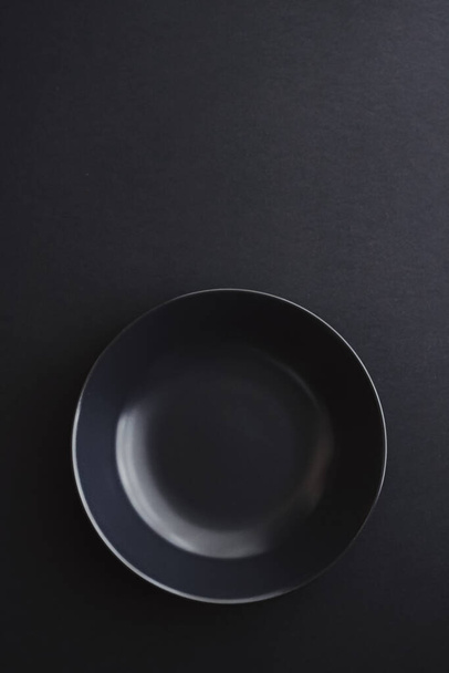 Empty plates on black background, premium dishware for holiday dinner, minimalistic design and diet - Foto, imagen