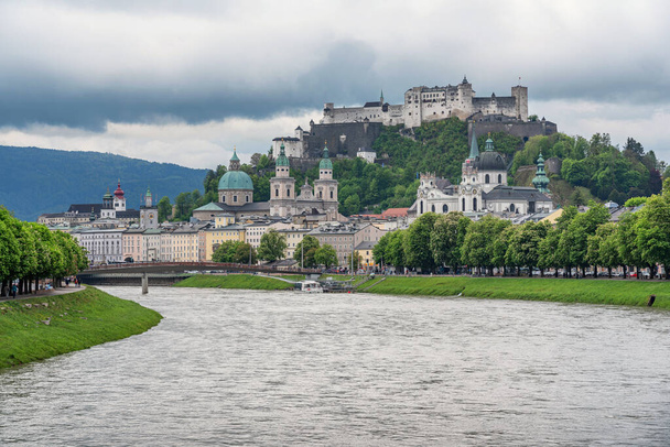 Klasszikus panoráma kilátás a történelmi város Salzburg híres Hohensalzburg erőd és idilli Salzach folyó egy gyönyörű tavaszi napon egy sötét drámai felhős táj, Salzburger Land, Ausztria - Fotó, kép