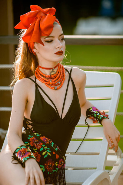 linda chica en traje de baño junto a la piscina al aire libre con accesorios étnicos y joyas, enfoque suave, sin marca, pin up posando, sombreros rojos
 - Foto, imagen