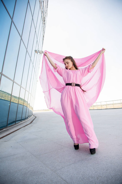 beautiful  young woman in pink dress posing on terrace  - Фото, зображення