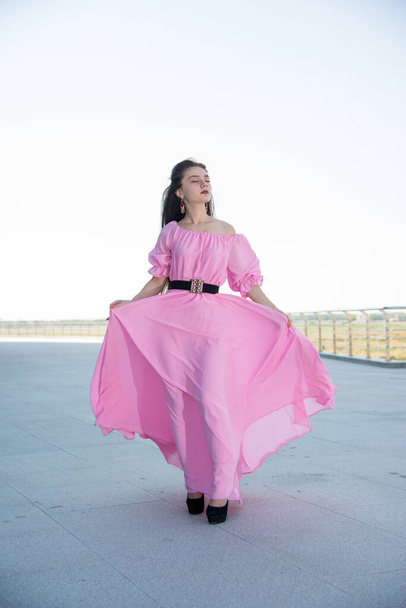 beautiful  young woman in pink dress posing on terrace  - Foto, imagen