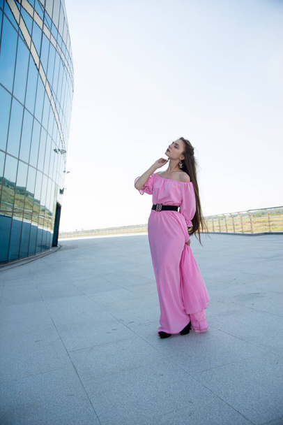 beautiful  young woman in pink dress posing on terrace  - Foto, Bild